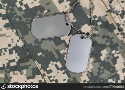 Military identification tags, neck chain, and combat uniform top. Military service concept.