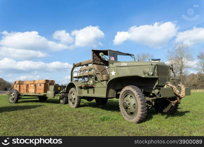 Military jeep pulling trailer carrying wooden boxes with bullets for war