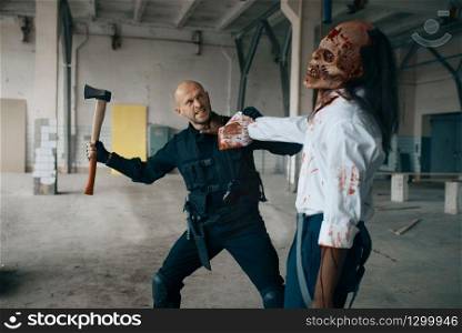 Military man with axe, battle with zombie in abandoned factory. Horror in city, creepy crawlies, doomsday apocalypse. Military man with axe, zombie in abandoned factory