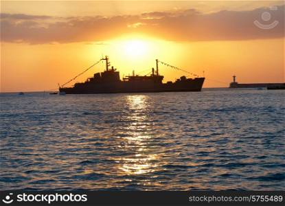 Military ship against beautiful red marine sunset