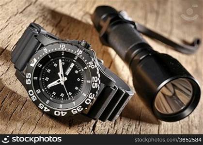 military watch and flashlight
