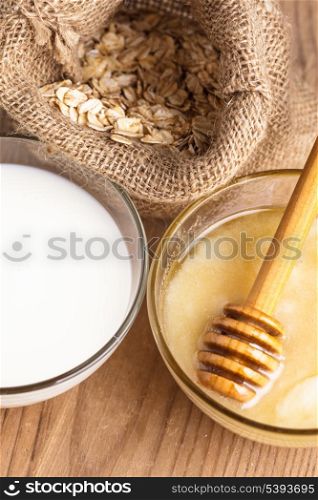 Milk and honey on the wooden table closeup