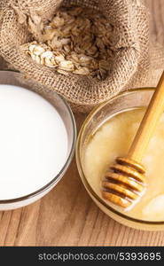 Milk and honey on the wooden table closeup