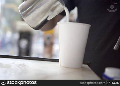 Milk being poured into a cup