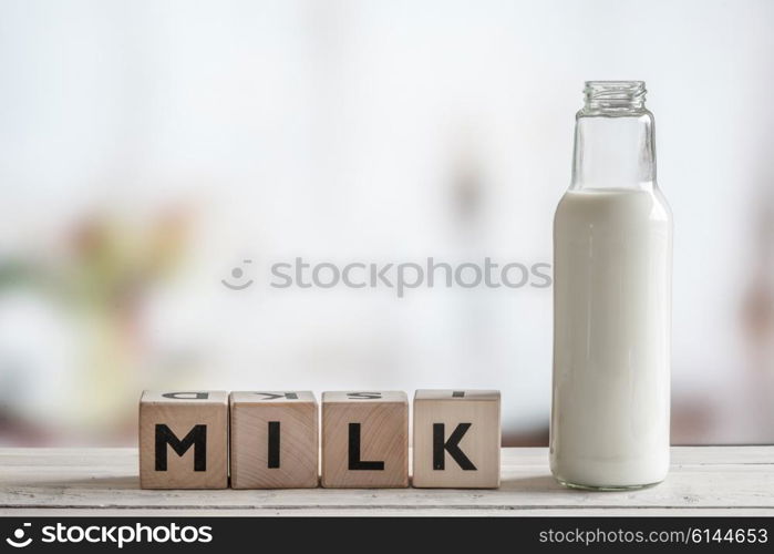 Milk bottle and the word milk on a wooden table