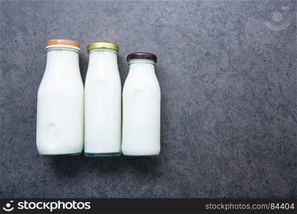 Milk bottle on dark stone background. Top view with copy space.