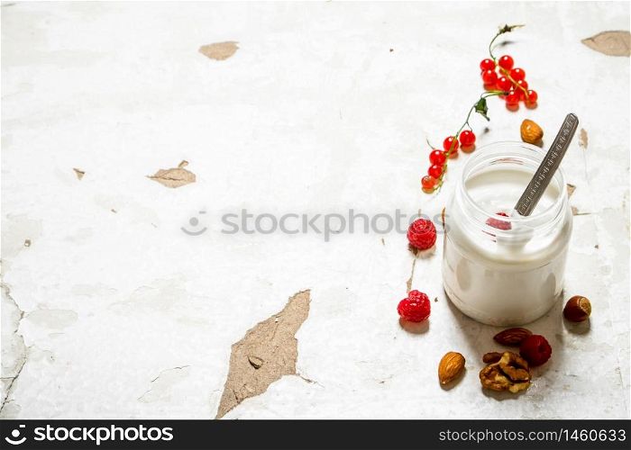 Milk dessert with nuts and wild raspberries. On rustic background.. Milk dessert with nuts and wild raspberries.