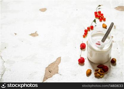Milk dessert with nuts and wild raspberries. On rustic background.. Milk dessert with nuts and wild raspberries.