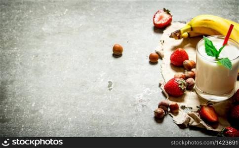 Milk dessert with nuts, berries and bananas. On the stone table.. Milk dessert with nuts, berries and bananas.