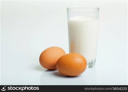 Milk in a glass jar and eggs on the table
