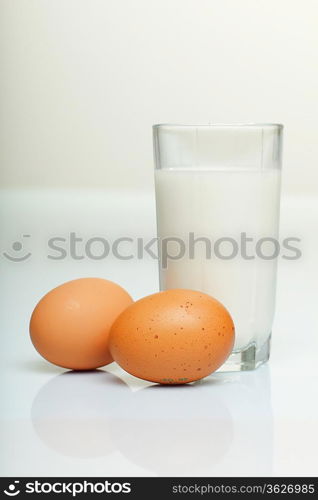 Milk in a glass jar and eggs on the table