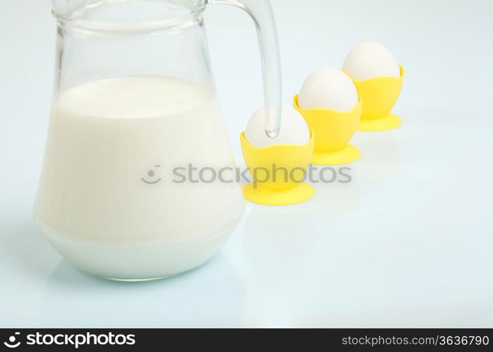 Milk in a glass jar and eggs on the table