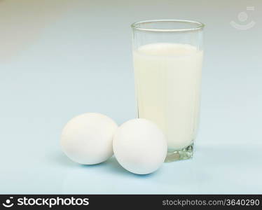 Milk in a glass jar and eggs on the table