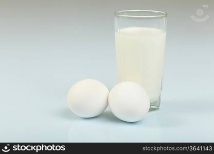 Milk in a glass jar and eggs on the table