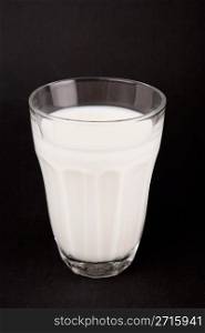 Milk in glass on a black background