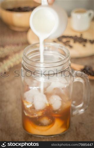 Milk pouring for fresh iced coffee, stock photo