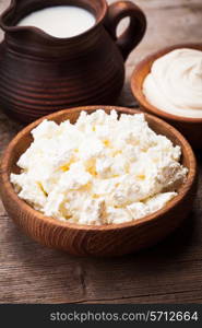 Milk, sour cream and curd on a wooden rustic board