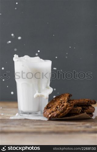 milk splashed glass with cookies