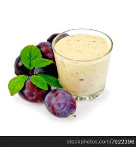 Milkshake in a glass with red plums and green leaves isolated on white background