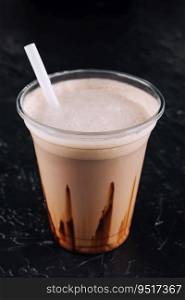 milkshake in a plastic cup on black background