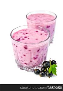 Milkshake in two low glassful, berries and green leaves of black currant isolated on a white background