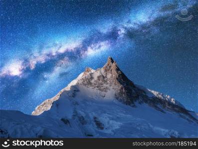 Milky Way above snowy mountains. Space. Fantastic view with snow covered rocks and starry sky at night in Nepal. Mountain ridge and sky with stars in Himalayas. Landscape with bright milky way. Galaxy