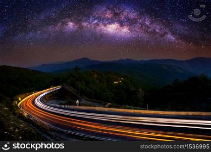 Milky way and car light on road at Doi Inthanon National park in the night, Chiang Mai, Thailand.