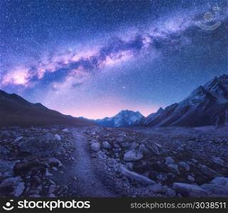 Milky Way and mountains. Space. Amazing view with mountains and starry sky at night in Nepal. Trail through mountain valley and purple sky with stars. Himalayas. Night landscape with bright milky way. Milky Way and mountains. Space