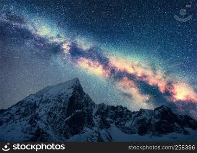Milky Way and snowy mountains. Space. Beautiful scene with snow covered rocks and starry sky at night in Nepal. Mountain ridge and sky with stars in Himalayas. Landscape with bright milky way. Galaxy