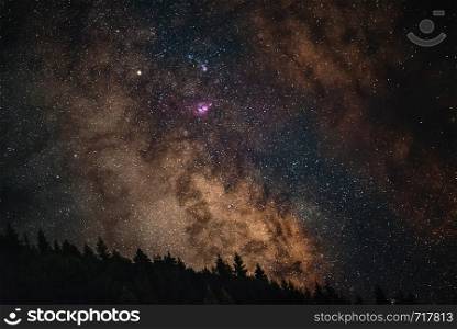Milky Way Galaxy in Racha, mountain silhoettes iluminated trees amazing nebula Beyond the clouds, Georgia