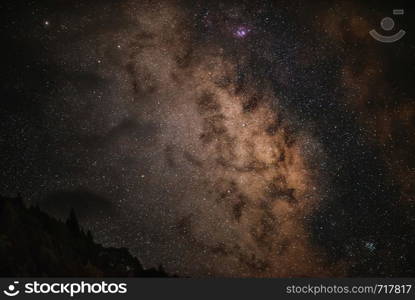 Milky Way Galaxy in Racha, mountain silhoettes iluminated trees amazing nebula Beyond the clouds, Georgia