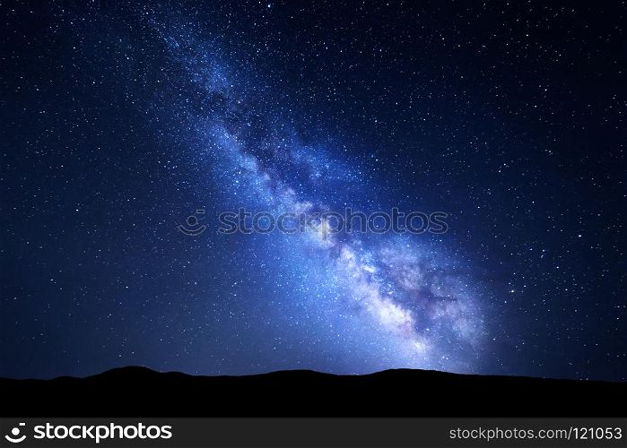 Milky Way. Night colorful landscape with stars. Starry sky with hills at summer. Space background with galaxy at mountains. Nature background with blue milky way. Universe