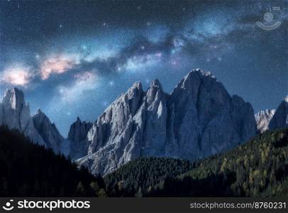 Milky Way over beautifull rocks at starry night in summer in Dolomites, Italy. Landscape with blue sky with stars and bright milky way over high alpine rocky mountains, trees. Space background. Nature