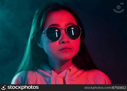 Millennial pretty asian girl with long hairstyle with neon light. Mysterious hipster teenager in glasses. Millennial pretty asian girl with long hairstyle with neon light. Mysterious hipster teenager in glasses.