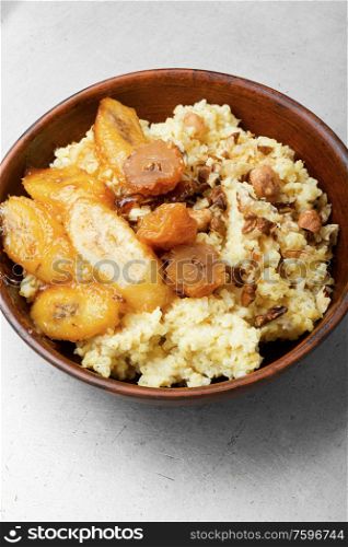 Millet porridge with caramelized bananas and nuts.Healthy breakfast. Millet porridge with banana