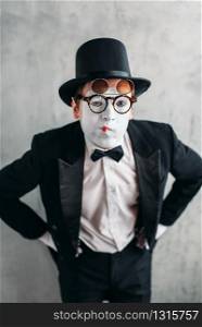 Mime actor in glasses and makeup mask. Pantomime in suit, gloves and hat. April fools day concept