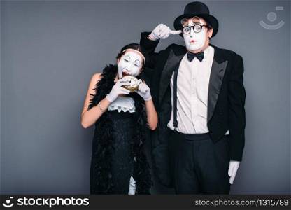 Mime actors performing, actress nibble alarm clock. Pantomime theater performers