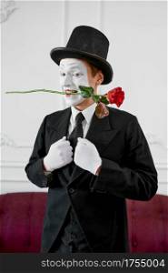 Mime artist, gentleman in love with a rose. Pantomime theater, parody comedian, positive emotion, humour performance, funny face mimic and grimace. Mime artist, gentleman in love with a rose
