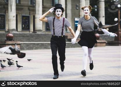mime couple running city pavement