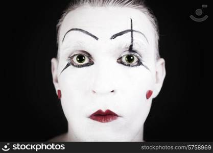 mime face with a theatrical makeup on black background