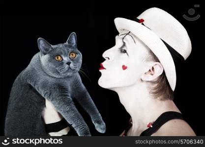 Mime in a white hat holding a gray cat British