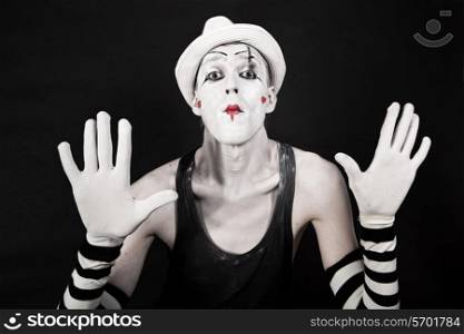 mime in striped gloves and white hat on black background