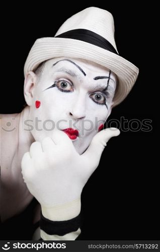 mime in striped gloves and white hat on black background