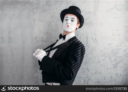 Mime male artist with white makeup mask. Comedy actor in suit, gloves and hat. Mimic person. April fools day concept