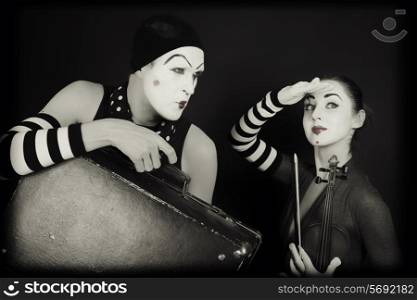 mimes woman and man with suitcase and violin