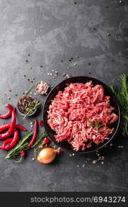 Mince. Ground meat with ingredients for cooking on black background. Top view