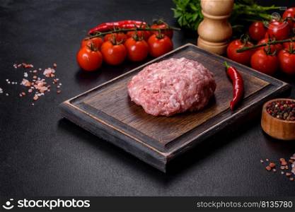 Mince. Ground meat with ingredients for cooking on black background. Top view. Ground meat with ingredients for cooking on black background