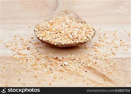 Minced garlic on wooden serving spoon with shallow depth of field