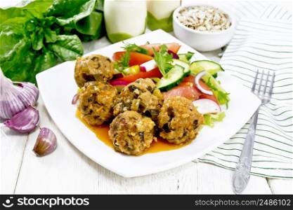 Minced meatballs with spinach, oatmeal and green onions in tomato sauce, vegetable salad in a plate, napkin on the background of a light wooden board