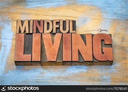 mindful living word abstract in letterpress wood type against grunge wooden background